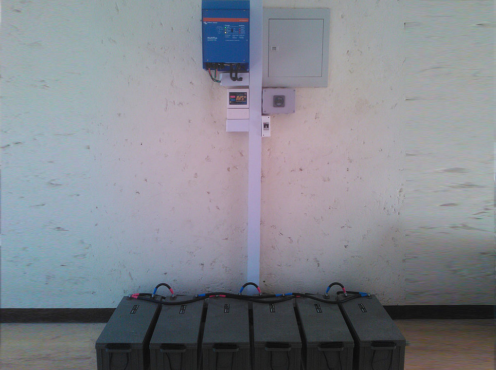 [Translate to Englisch:] Das bild zeigt einen typische Installation von Batterien und einem Wechselrichter in Tansania.